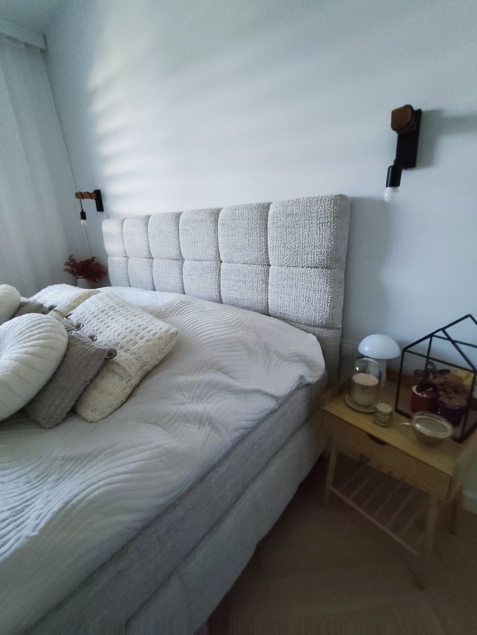 Łóżko z miękkim modułowym zagłówkiem w jasnej sypialni
